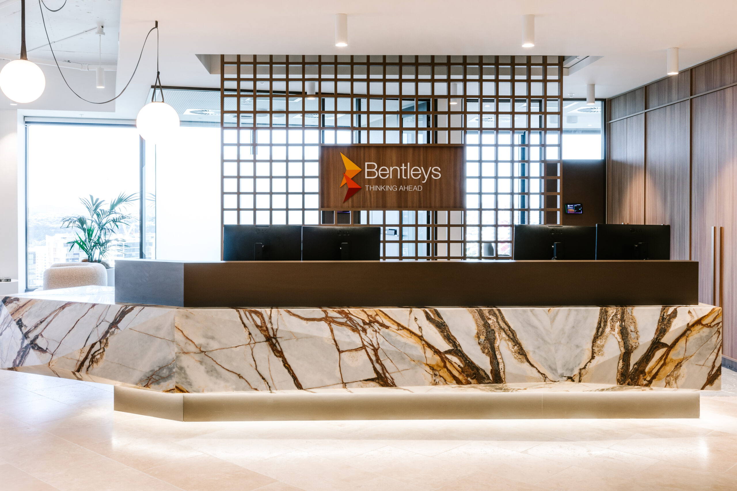 Elegant marble reception desk with Bentleys logo and "Thinking Ahead" branding at their Brisbane headquarters