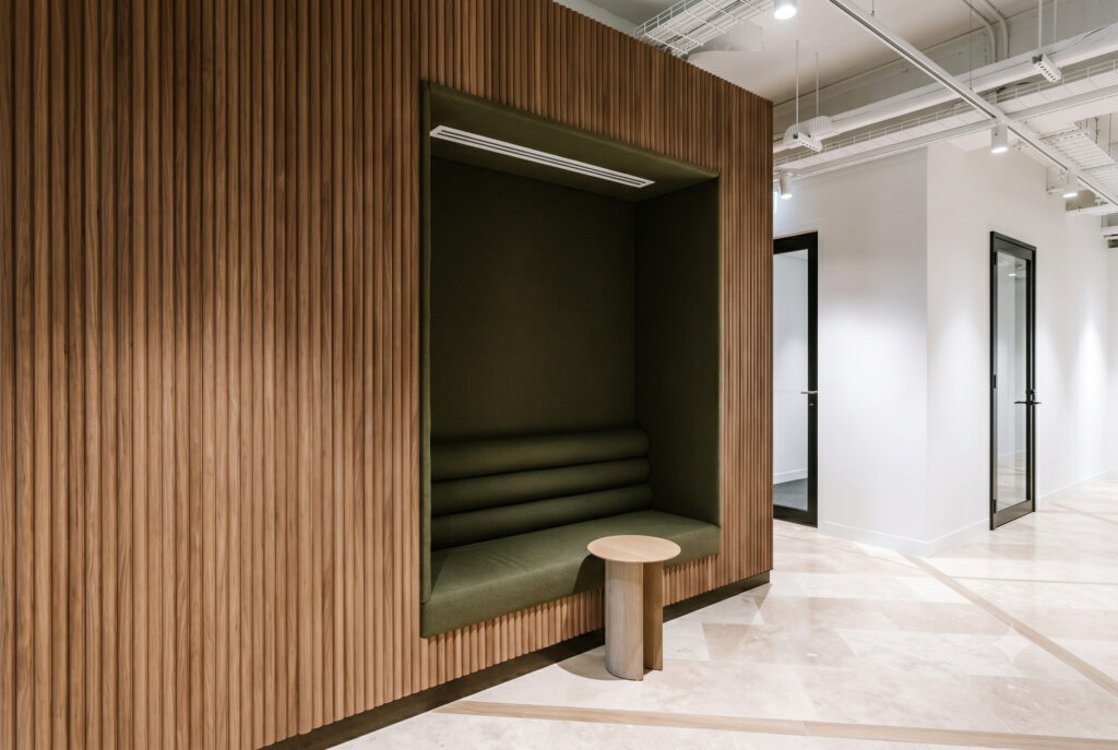 Private acoustic timber booth with deep green upholstered seating and side table at Bentleys Queensland office
